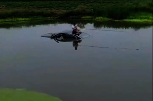 汽车冲进池塘，屋顶的钓鱼被救出。